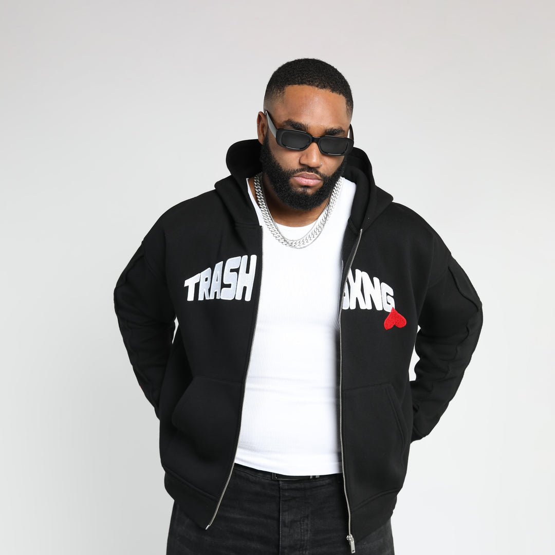 Man wearing OG Love black hoodie with text and a red heart design on a white background