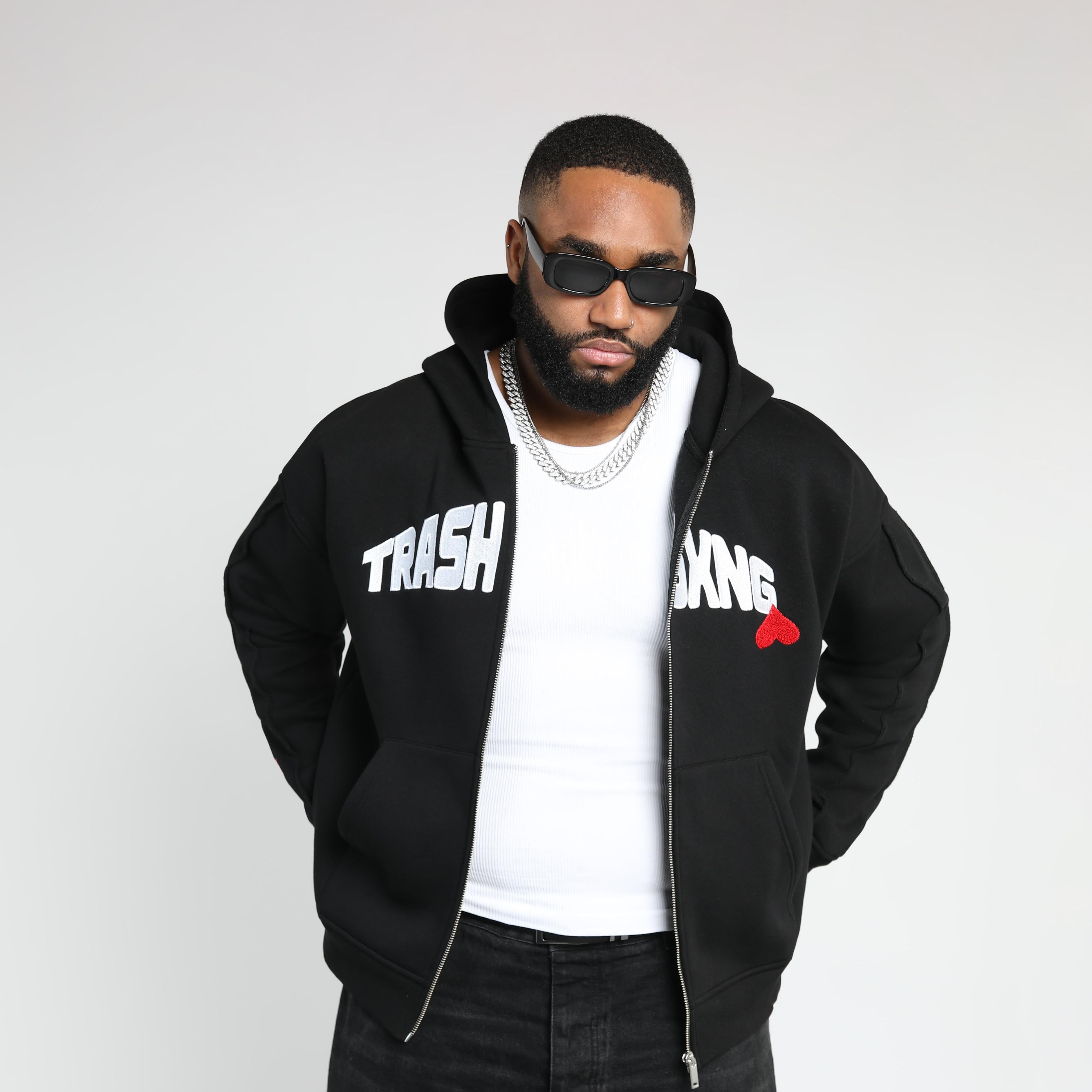Man wearing OG Love black hoodie with text and a red heart design on a white background